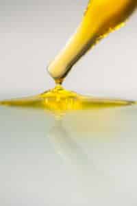 Drop of oil being placed on clear table, healthy fat source